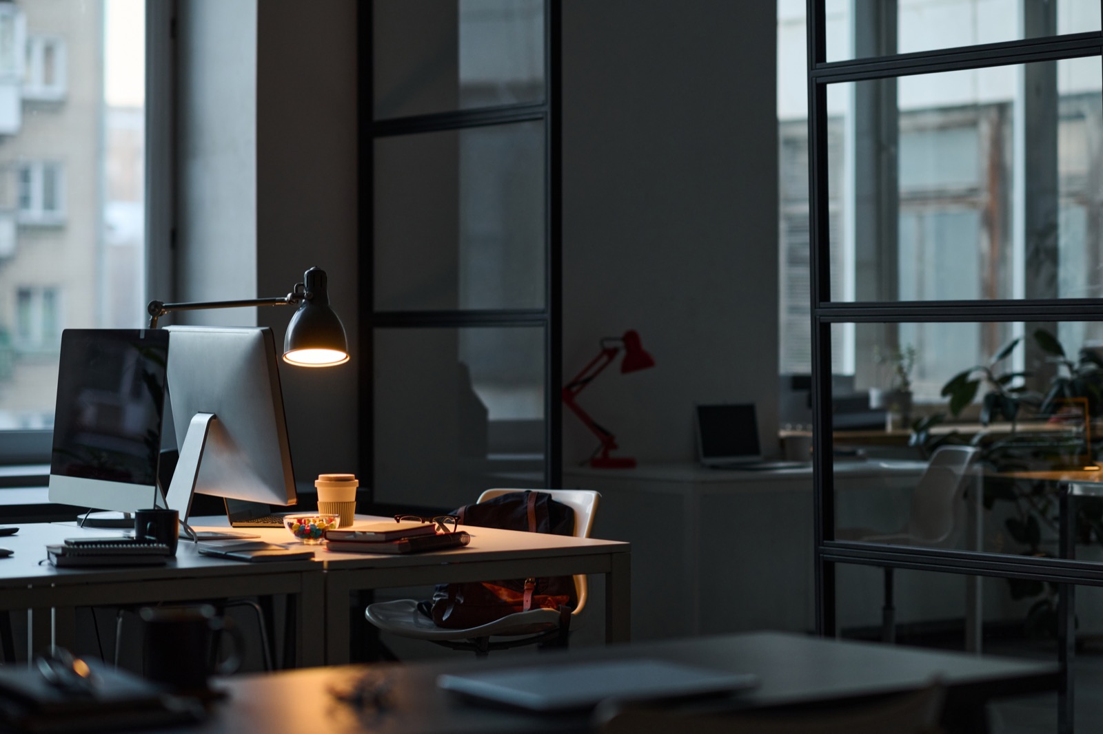 Arbeitsplatz bei Nacht mit Bildschirm und Lampe
